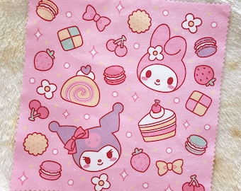 May include: Pink fabric with a repeating pattern of cartoon characters, desserts, and flowers. The characters are a pink rabbit with a bow and a purple cat with a bow. The desserts include a cake, a roll cake, and macarons. The flowers are white and yellow.