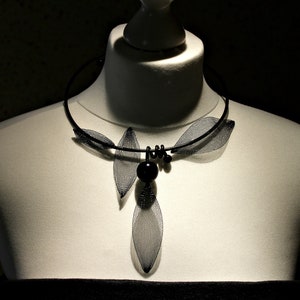 May include: A black mesh choker necklace with a dangling leaf design and black beads.