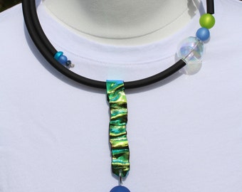 Bright colored necklace of unusual shape with aurora borealis effect in blue and green colors and black rubber