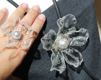 Un long collier lariat avec une grande fleur transparente et un long collier à pendentif long et épais en perles