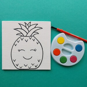 K&ouml;nnte beinhalten: Eine wei&szlig;e Leinwand mit einer schwarzen Linienzeichnung einer l&auml;chelnden Ananas. Neben der Leinwand befindet sich eine blaue und wei&szlig;e Farbpalette mit roter, gelber, gr&uuml;ner und blauer Farbe.