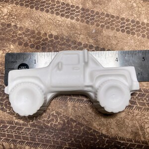 4.5 inch plaster monster truck magnet with large wheels.