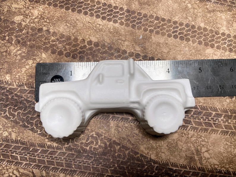 4.5 inch plaster monster truck magnet with large wheels.