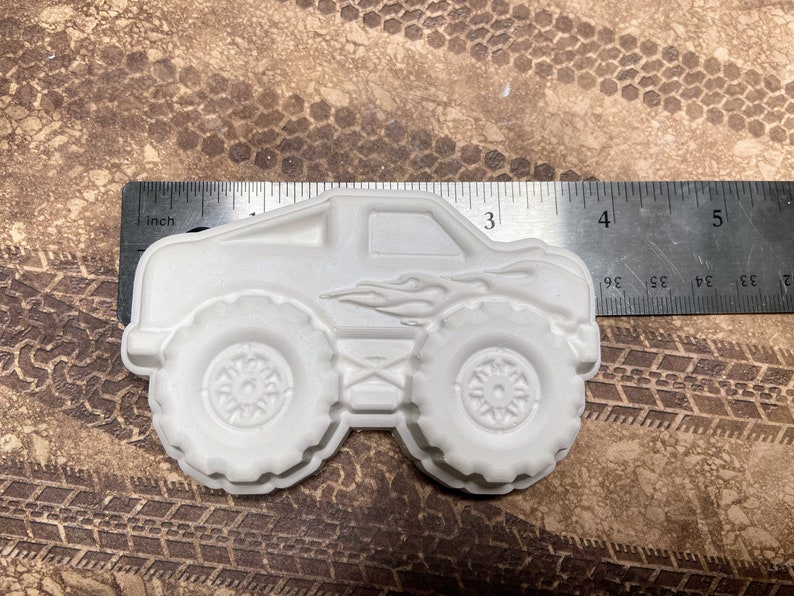 3.8 inch plaster monster truck magnet with flames on the side.