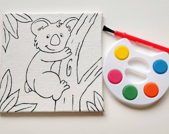 Puede incluir: Un kit de pintura por números con un dibujo en blanco y negro de un koala en una rama de árbol. El kit incluye una pequeña paleta de pintura con seis colores diferentes y un pincel.