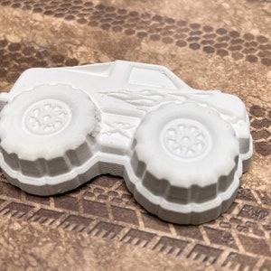 Close up of plaster monster truck with flames on the side.