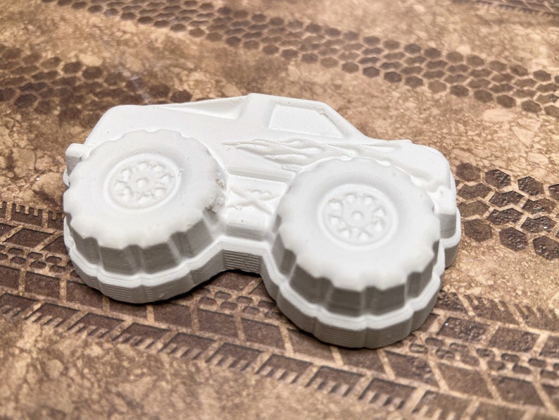 Close up of plaster monster truck with flames on the side.