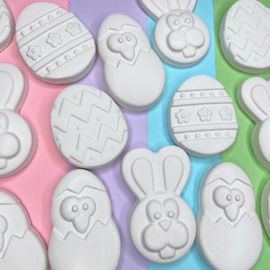 May include: A set of 12 blank, white ceramic Easter-themed ornaments. The ornaments feature bunny rabbits, eggs, and other Easter designs. The ornaments are ready to be painted.