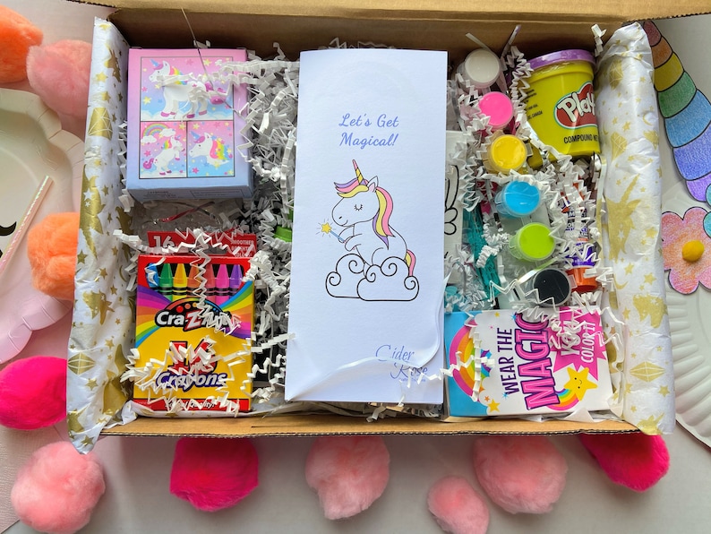 Unicorn themed craft box with a unicorn puzzle, two unicorn crafts to make, a unicorn canvas to paint, unicorn and rainbow magnets to paint, play dough, unicorn activity and coloring pages, three fun recipes, a unicorn cookie cutter with recipe.