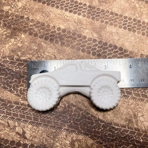 3.5" plaster monster truck magnet with long body and big wheels.