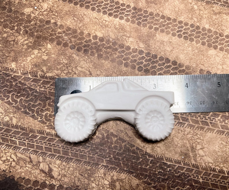 3.5" plaster monster truck magnet with long body and big wheels.