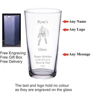 May include: A personalised glass featuring a black and white illustration of a superhero. The glass is engraved with the text "Ryan's" at the top, "Glass" in the middle, and "Happy Birthday Lots of Love Mum & Dad XXX" at the bottom.