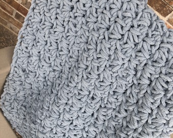 May include: A soft, blue crocheted blanket with a textured, star-shaped stitch pattern.