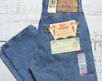May include: A pair of blue denim jeans with a Levi's 501 label and size tag. The jeans have a light wash and are made of cotton.