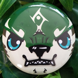 May include: A green and white button with a cartoon animal face. The animal has a green face with a white symbol on its forehead, white fur, and a black nose and mouth. The animal is looking angry.