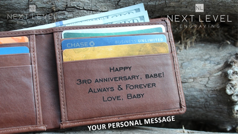 May include: A brown leather wallet with a personalized message that reads "Happy 3rd Anniversary, Babe! Always & Forever Love, Baby". The wallet has a credit card slot and a money clip.