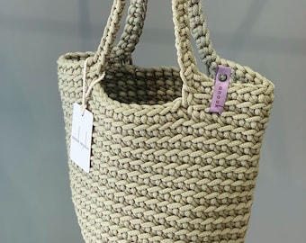 May include: A beige crocheted tote bag with a pink label that says "anouk".
