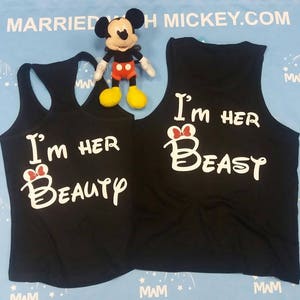 May include: Two black tank tops with white text that says "I'm her Beauty" and "I'm her Beast" with a red bow on the "B".