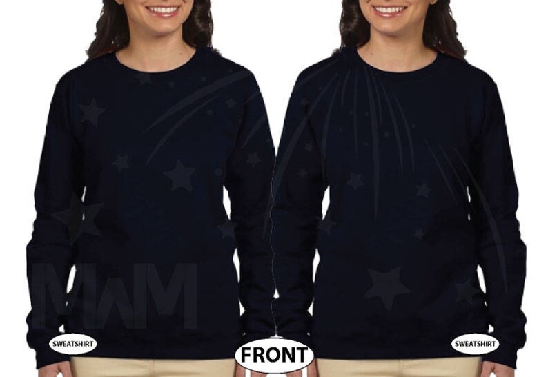 May include: A navy blue long-sleeved sweatshirt with a black and white design of shooting stars and stars. The sweatshirt has the word "SWIM" printed on the front.