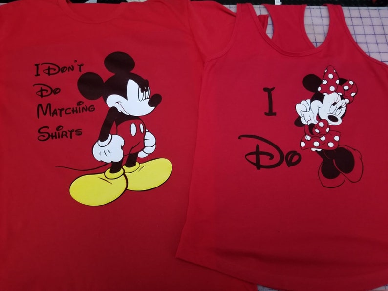 May include: Red t-shirt with Mickey Mouse and the text "I Don't Do Matching Shirts". Red tank top with Minnie Mouse and the text "I Do".