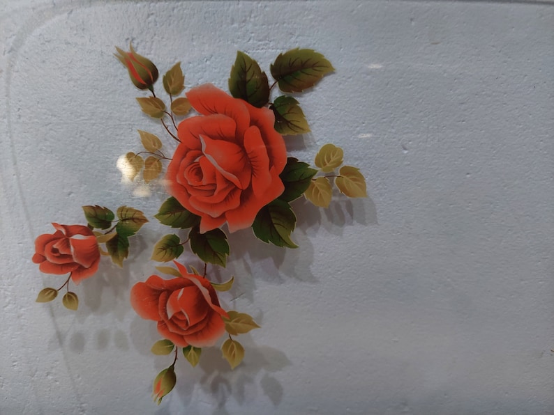 Pode incluir: Um desenho pintado de rosas vermelhas com folhas verdes sobre um fundo branco.