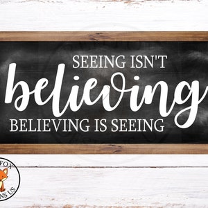 Può includere: Una lavagna nera con una cornice in legno bianco. La lavagna ha testo bianco che dice "Vedere non è credere. Credere è vedere."