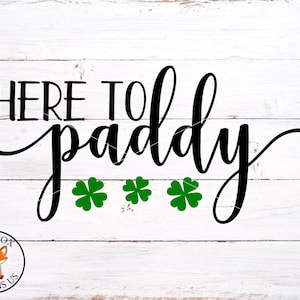May include: Black and white text on a white wood background that reads "Here to paddy" with three green shamrocks.