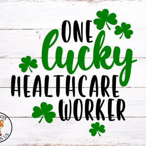 May include: A white wooden background with a black and green graphic that reads "One lucky healthcare worker". The graphic is decorated with green shamrocks.