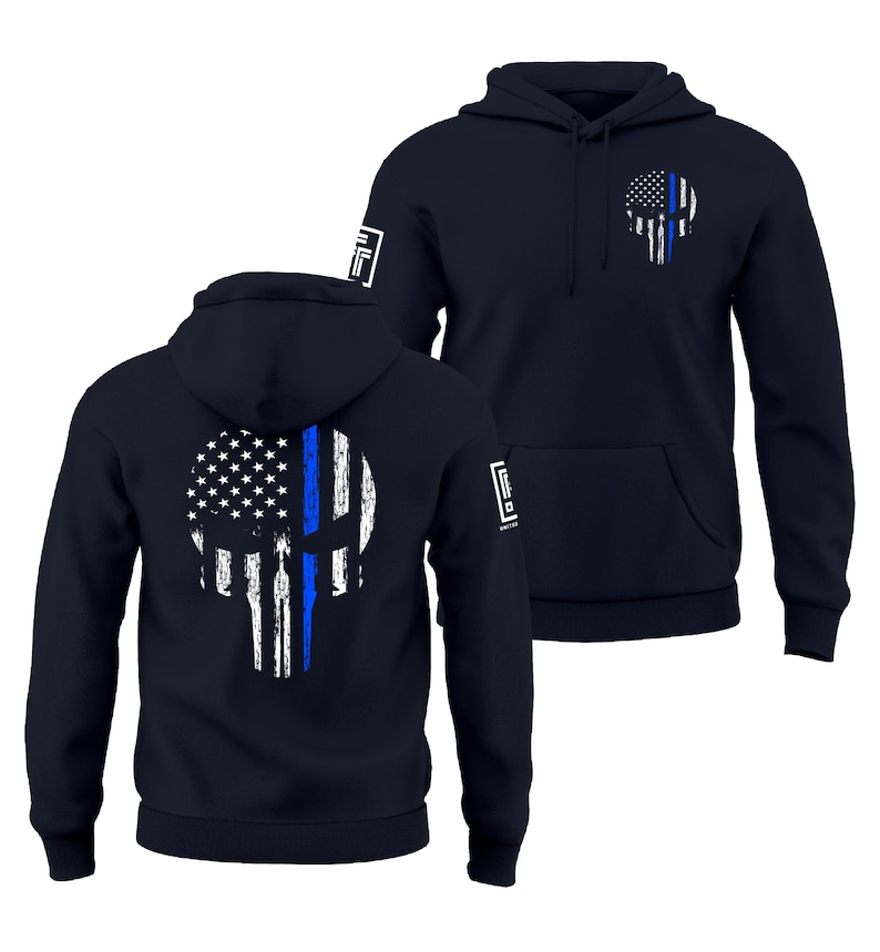 May include: Navy blue hoodie featuring a distressed skull design with the American flag and a blue line. The hoodie has a front pocket and a hood. The design is on the front and back of the hoodie. The hoodie has a logo on the sleeve.