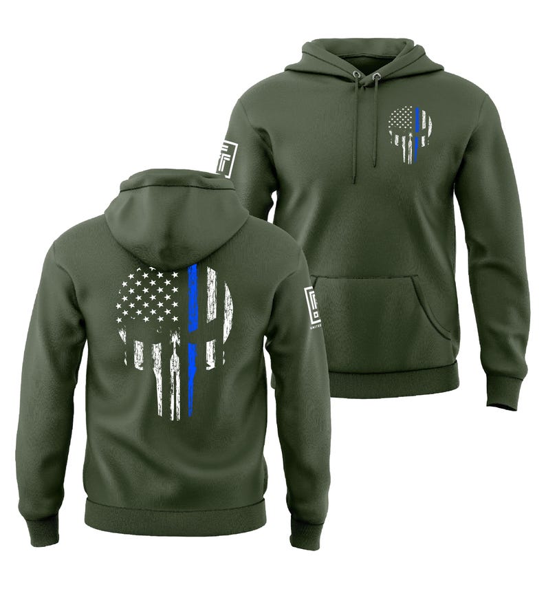 May include: Olive green hoodie featuring a distressed skull design with a blue line and American flag elements. The hoodie has a front pocket, a hood, and a logo on the sleeve. The design is on the front and back.