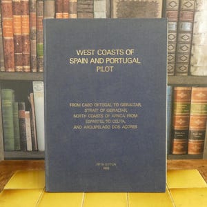 Peut inclure: Un livre bleu marine intitulé "WEST COASTS OF SPAIN AND PORTUGAL PILOT" avec des lettres dorées. La couverture du livre énumère également des lieux de Cabo Ortegal à Gibraltar et les côtes d'Afrique du Nord. Il s'agit d'une cinquième édition de 1972.