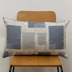 Cuscino rettangolare XL con motivo geometrico astratto quadrato. Ciniglia morbida intrecciata in stile patchwork. Blu navy, denim e grigio. 58x38 cm, double-face.