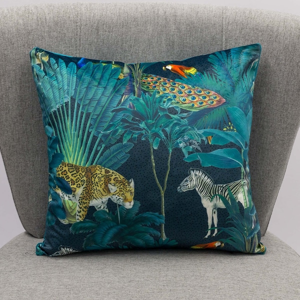 Coussin en velours forêt de palmiers. Oiseaux exotiques et animaux de la jungle sur fond bleu sarcelle brillant. Soutenu par un velours doux sarcelle uni. Carré de 17".