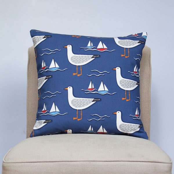 Housse de coussin By the Sea Gull. Imprimé mouette et yacht bleu marine d'inspiration nautique. Housse de coussin carrée 17 x 17 po.