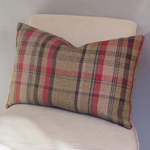 Könnte beinhalten: Ein braunes, rotes und schwarzes Kissen mit kariertem Muster aus weichem, strukturiertem Stoff.