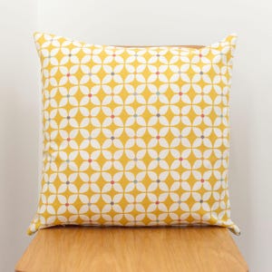 Cuscino stampato geometrico retrò eccentrico in giallo estivo. Design geometrico a stella floreale con dettagli multicolore. 100% cotone, fodera da 17" quadrati
