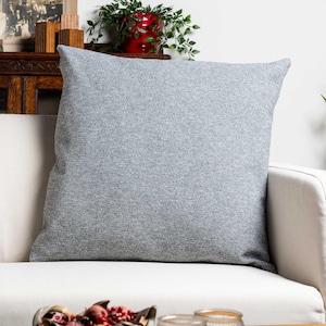 Klassisk extra stor kudde i fiskbensmönstrad tweed i stengrått. Mjukt grått, traditionellt rutmönster. Fyrkantigt kuddfodral i 63x63 cm.