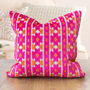 Cojín Kasmere de terciopelo con estampado geométrico. Estampado geométrico triangular en rosa brillante y naranja quemado. Funda de cojín de 43 x 43 cm.