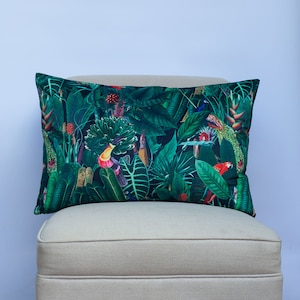 May include: A green cushion with a tropical print featuring colourful birds and lush foliage.