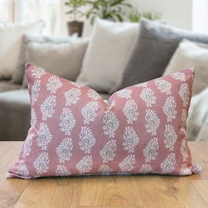 May include: A pink cushion with a white and grey floral pattern. The cushion is made from a soft, comfortable fabric and is ideal for adding a touch of elegance to any room.