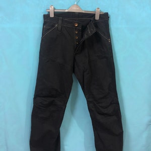 May include: Black denim pants with multiple pockets and a button fly.