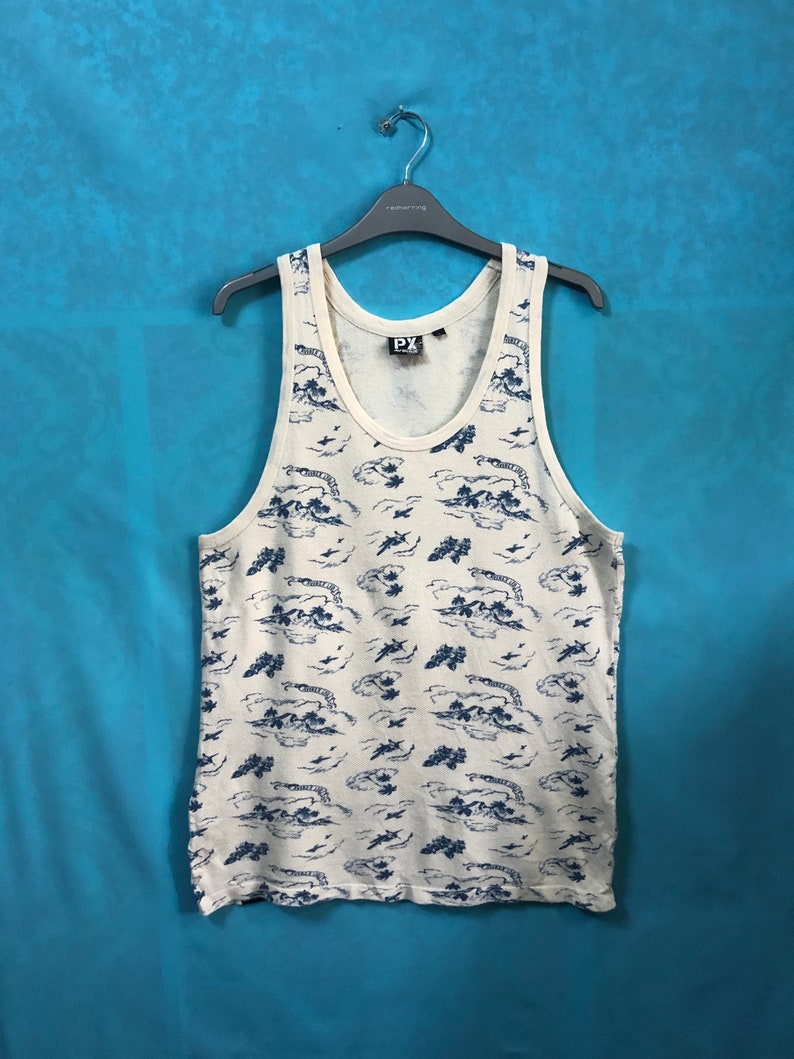 May include: A white tank top with a blue and white print of islands and airplanes. The tank top has a scoop neck and a relaxed fit. The brand name "PX" is printed on the front of the tank top.