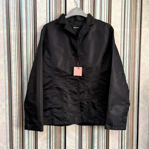 May include: A black long-sleeved jacket with a button-up front and two pockets. The jacket has a collar and is hanging on a hanger.