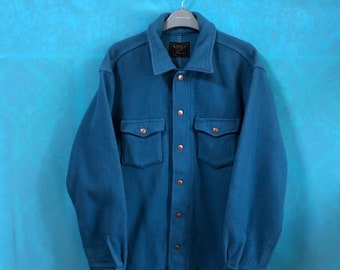 May include: A blue long-sleeved shirt with a button-up front and two large pockets. The shirt has a brown label with the text "KINLY" on it.