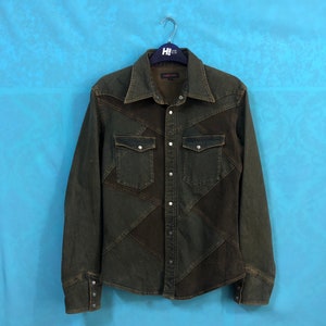 Könnte beinhalten: Ein dunkelgrünes Jeanshemd mit Patchwork-Design. Das Hemd hat einen Knopfleistenverschluss, lange Ärmel und zwei Brusttaschen.