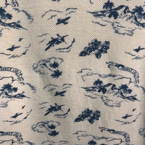 May include: A white fabric with a blue pattern of palm trees, airplanes, and clouds. The fabric has the text "AVIREX LTD" repeated throughout the pattern.