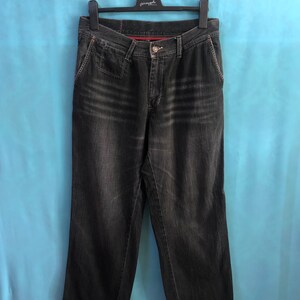 May include: A pair of dark wash denim jeans with a straight leg fit. The jeans have a button fly and belt loops.