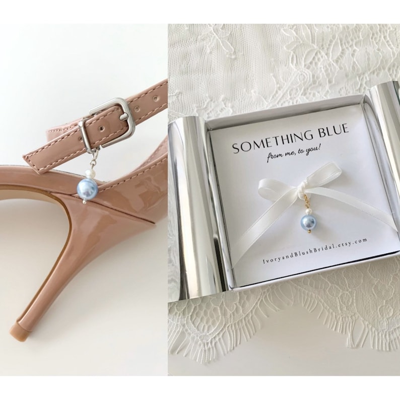 May include: A small blue pearl charm with a white pearl and gold chain, attached to a white ribbon with a bow. The charm is in a white box with the text "Something Blue from me, to you!" and the website "IvoryandBlushBridal.etsy.com".