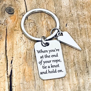 May include: Silver keychain with a heart charm and a rectangular tag that reads "When you're at the end of your rope, tie a knot and hold on."