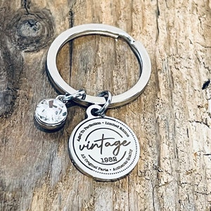 May include: Silver keyring with a round charm that says "Vintage 1988" and "Made to Perfection - Limited Edition - All Original Parts - Authentic Craftsmanship".